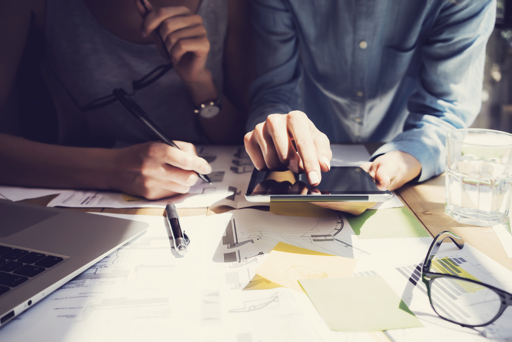 Photo Woman Hand Touching Digital Tablet Screen.Analytics Department Researching Process.Young Business Crew Working New Startup modern Studio.Analyze markets stocks.Blurred,film effect.Horizontal
